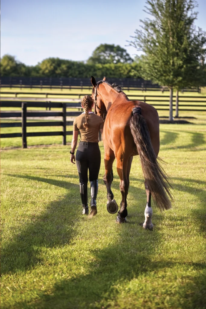 Kobieta prowadząca konia z opaską Garmin Blaze
